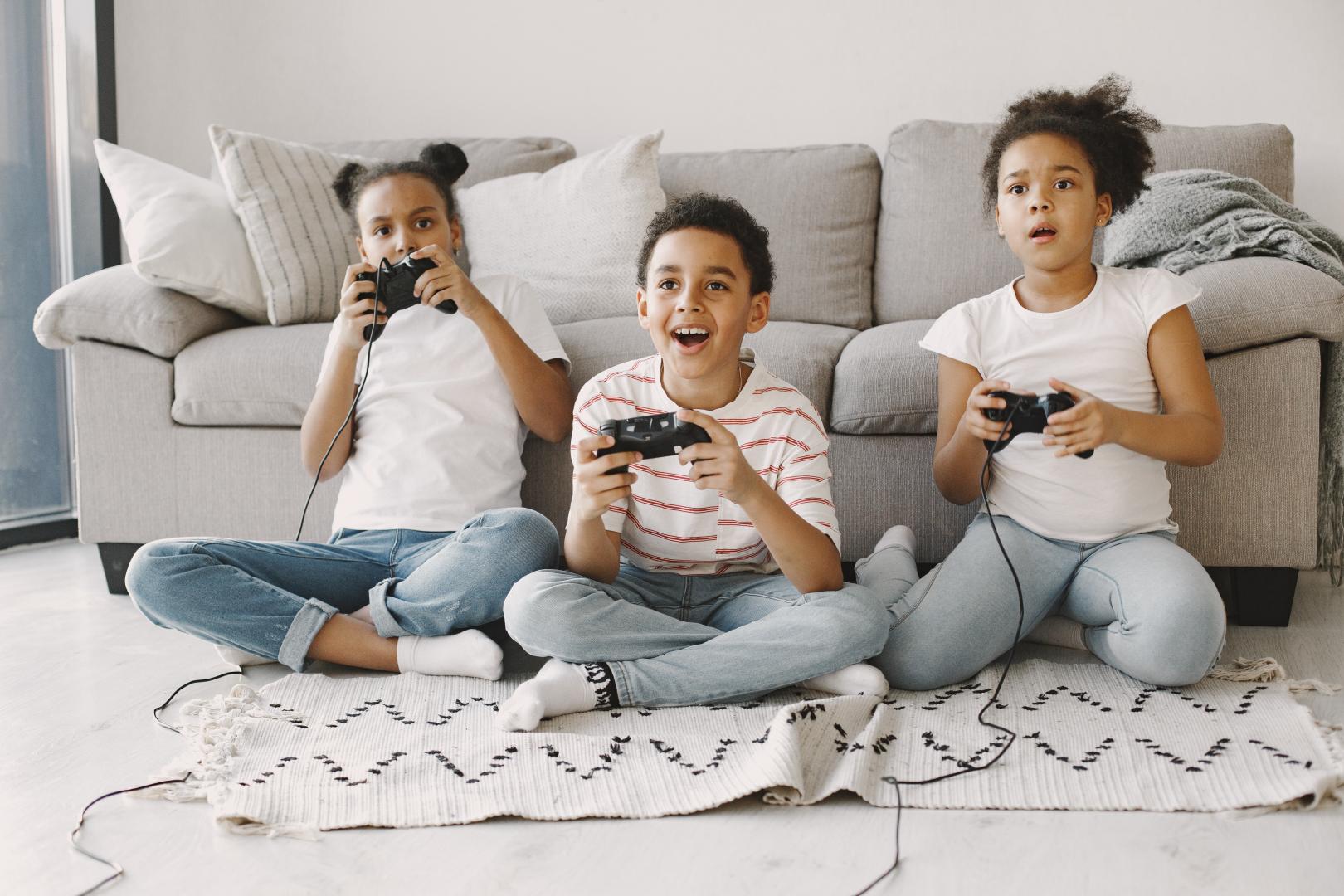 Children play in video games at home on floor